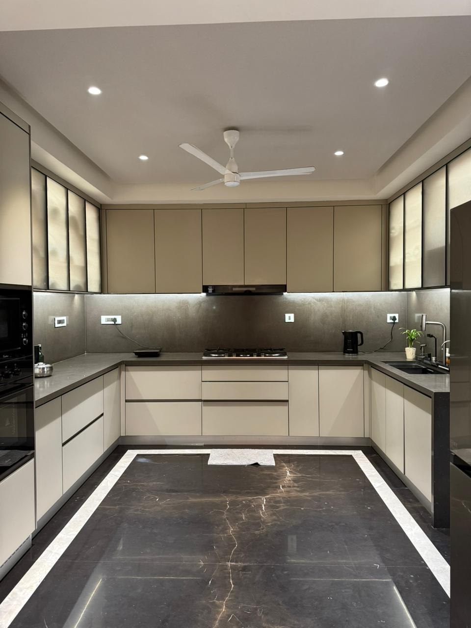 Wide U-shaped kitchen with handleless cabinetry and granite countertops